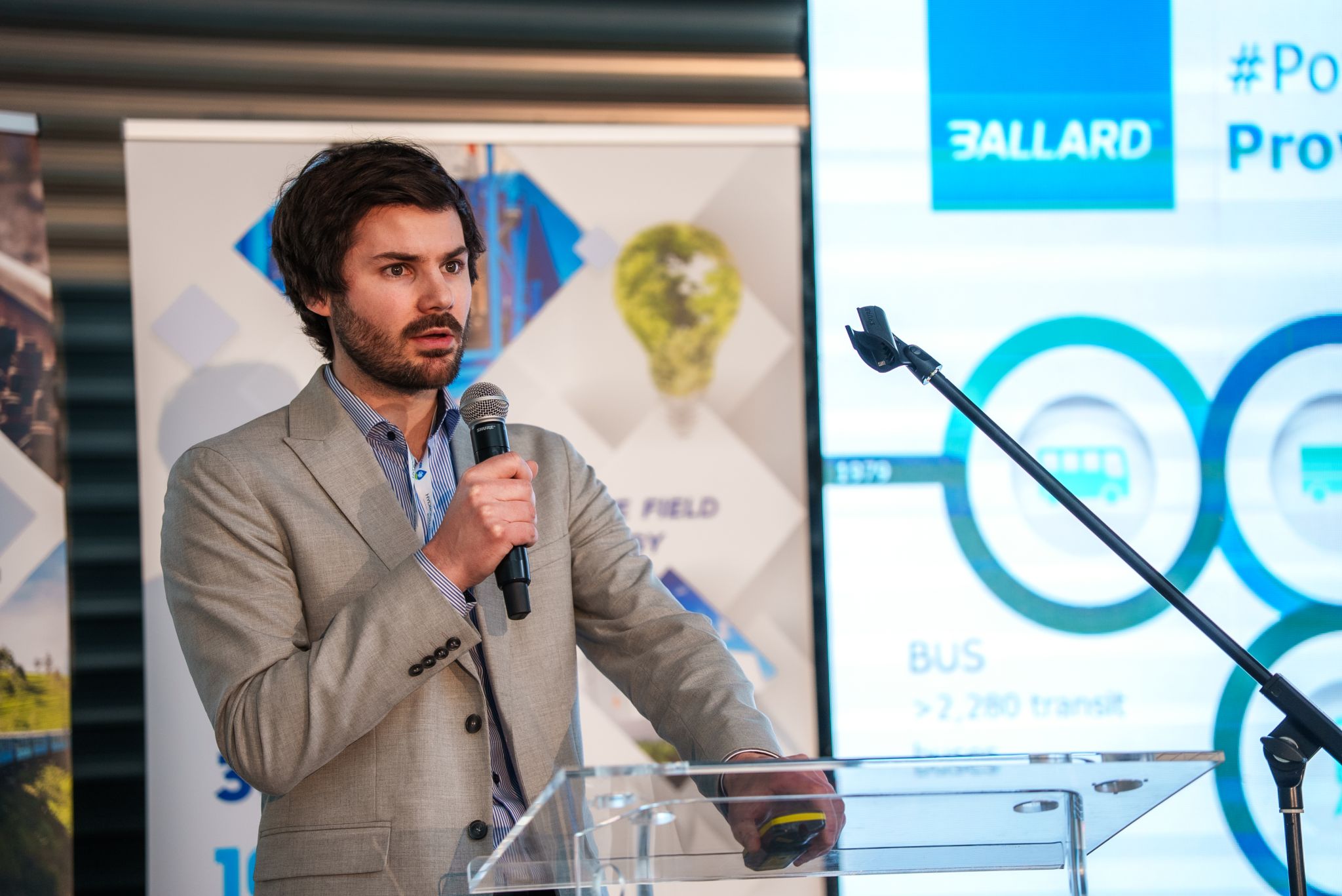 Ballard's Julien Masson holding a microphone and presenting at GANZAIR's hydrogen technology day in Hungary