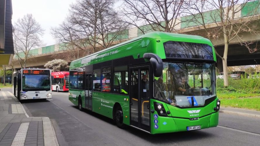 A green Wrightbus Kite Hydroliner fuel cell bus leads two other zero-emission transit buses during a test drive in Bonn, Germany